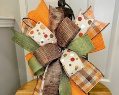 an orange and green bow on top of a wooden table next to a white door