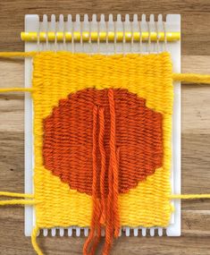 an orange and yellow piece of yarn sitting on top of a table