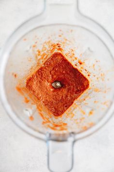 an overhead view of a blender filled with something red or orange in it's bottom