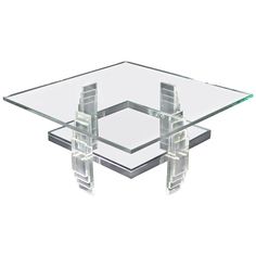 a square glass table with four legs and an acrylic frame on the top