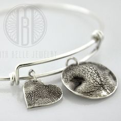 Made from your pet's actual nose (or paw) prints... This listing is for one small (~16 mm) dog nose charm and one large (~21 mm) paw print charm; both in pure, solid silver (.999). Our bangles are anti-tarnish sterling silver and they come in 2 sizes (7" adjustable bangle and 8.5" adjustable bangle). Add your dog's name or initials on the back of the charm as an engraving for FREE (optional) **Includes Free Shipping of the mold kit which includes a prepaid return label (US only) as well as mold Silver Paw Print Jewelry For Anniversary, Silver Jewelry With Paw Print For Anniversary, Silver Anniversary Jewelry With Paw Print, Adjustable Paw Print Jewelry For Anniversary, Adjustable Silver Jewelry With Paw Print, Adjustable Sterling Silver Paw Print Jewelry, Adjustable Sterling Silver Jewelry With Paw Print, Silver Jewelry With Paw Print, Sterling Silver Jewelry With Paw Print