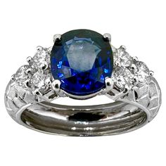 This well constructed vintage platinum ring is set with one rich and vibrant natural blue, oval faceted sapphire weighing exactly 2.33ct, flanked by six brilliant cut diamonds weighing .55ct total of overall G color and VS2 clarity. The shoulders of the mounting are engraved in a textured, mosaic design. The 1/2 round shank is high polish finish. Stamped into the inside are 900pt, designating the metal, as well as the exact sapphire and diamond weights. Ring is size 6 3/4. Gross weight grams. Vintage Platinum Rings, Blue Sapphire Diamond Ring, Mosaic Design, Blue Sapphire Diamond, Mosaic Designs, Platinum Ring, Brilliant Cut Diamond, Vintage Stil, Blue Sapphire