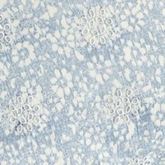 a blue and white fabric with small flowers on it's side, as well as an intricate design