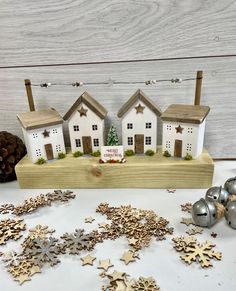 a wooden box filled with christmas decorations next to silver and gold ornaments on top of a white table