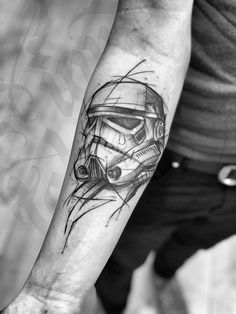 a man's arm with a star wars helmet tattoo on the left inner forearm