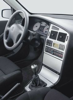 the interior of a car with steering wheel controls and dashboard buttons, including an electronic display