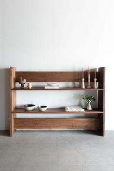 a wooden shelf with bowls and plates on it