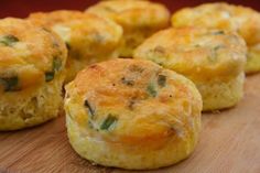 several small muffins sitting on top of a wooden cutting board