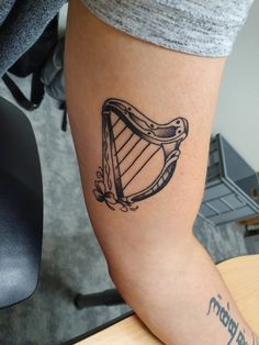 a tattoo on the leg of a woman with a harp in it's hand