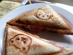 two slices of toasted bread with smiley faces on them sitting on a white plate