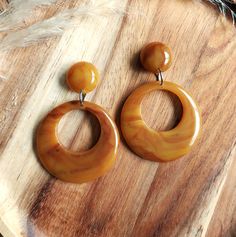 I have made these fabulous statement drop hoop earrings in resin, using a mix of yellow and brown colouring to give them their fabulous swirled appearance. The drop hoops have a classic 1950's style and measure 42mm in diameter. They are fixed to the top studs which are 17mm in diameter and have a 6mm dome. They are finished with stainless steel earring posts and have an total drop of 62mm. They are incredibly lightweight making them easy to wear. They will look amazing with your vintage dresses Light Weight Jewelry, Rockabilly Fashion, Colorful Earrings, Stainless Steel Earrings, Brass Earrings, Yellow And Brown, Post Earrings, Favorite Jewelry, Jewelry Earrings Dangle