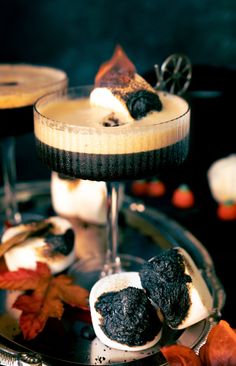 two desserts on a silver tray with leaves and pumpkins around the rim,