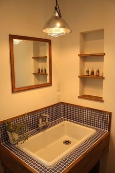 a bathroom sink sitting under a mirror next to a shelf