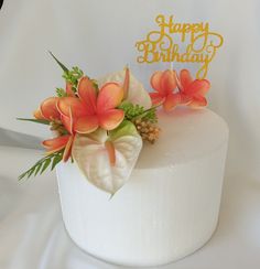 a white cake topped with flowers and a happy birthday sign