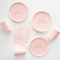 pink party plates and napkins with the words happy birthday on them