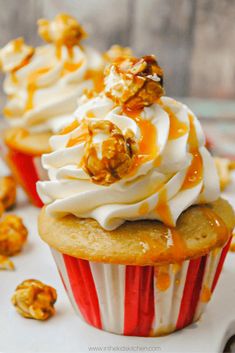 two cupcakes with white frosting and caramel drizzle on top