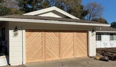 a white house with two garage doors on each side