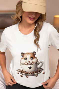 Snuggle up with style and cuteness overload with our Adorable Hamster Coffee Cup T-Shirt! This cozy and comfortable tee showcases an irresistibly cute hamster peeking out from a coffee cup, guaranteed to melt hearts and spark joy with every wear. Perfect for casual outings or lounging at home, this unisex t-shirt serves as a wonderful gift for animal lovers, pet owners, and coffee aficionados alike. Crafted with high-quality materials, it promises lasting comfort and durability. Available in var Cute Hamsters, Spark Joy, Animal Lovers, Cuteness Overload, Pet Owners, Top Tee, Body Types, Coffee Cup, Animal Lover