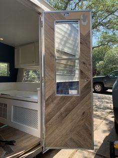 the inside of a mobile home with its door open and windows opened to reveal an outside kitchen area