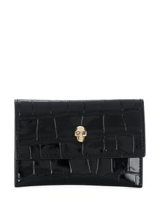 Black leather Skull stud purse from Alexander McQueen featuring crocodile effect, gold-tone hardware, front flap closure, press-stud fastening, internal logo stamp, rear logo stamp and two internal slot pockets. | Alexander McQueen Skull stud purse Alexander Mcqueen Wallet, Black Alexander Mcqueen, Alexander Mcqueen Bag, Alexander Mcqueen Skull, Studded Purse, Croc Leather, Black Leather Wallet, Designer Wallets