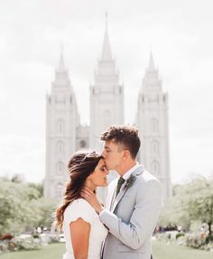 a bride and groom kissing in front of the salt lake temple