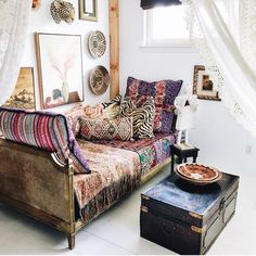 a living room filled with lots of furniture and pictures on the wall next to a window