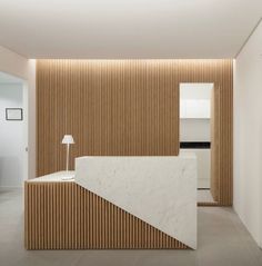 a white counter sitting in the middle of a room next to a wooden paneled wall