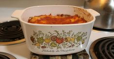 a casserole dish is sitting on the stove with other cooking utensils nearby