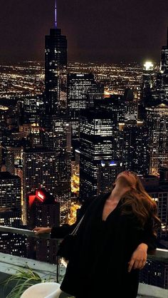 a woman leaning over a toilet in front of a cityscape at night with the lights on