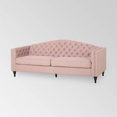 a pink couch sitting on top of a white floor