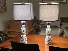 two blue and white lamps sitting on top of a wooden table next to each other