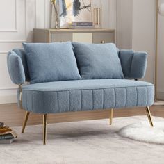 a blue couch sitting on top of a white rug