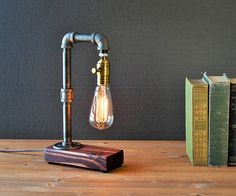 a lamp that is sitting on top of a table next to some books and a book