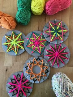 several balls of yarn sitting next to each other on a wooden floor with crochet stars