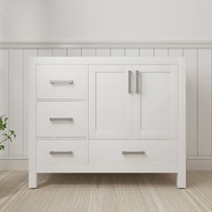 a white bathroom vanity with two drawers and a potted plant on the floor next to it