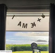 a chair sitting in front of a window next to a sign that says i am 43