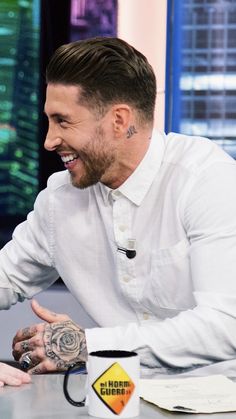 a man sitting at a table with a mug in front of him