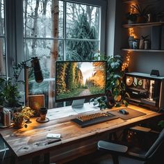 a desktop computer sitting on top of a wooden desk in front of a large window