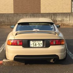 a tan sports car parked in a parking lot