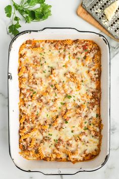 a casserole dish filled with meat and cheese on top of a marble counter