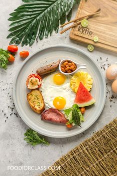 a plate with eggs, bacon, watermelon and other food items on it