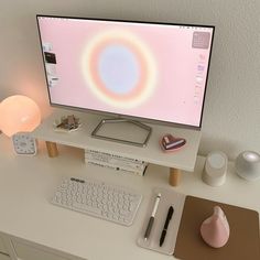 a computer monitor sitting on top of a white desk next to a keyboard and mouse