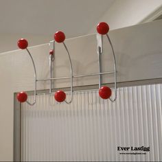 several red balls hang from a metal rack