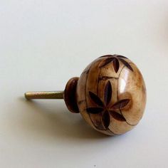 a close up of a wooden knob on a white surface