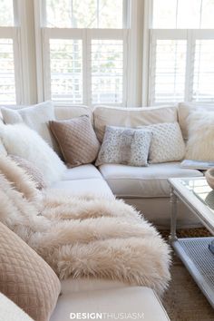 a living room filled with lots of furniture and white fur on top of it's couch