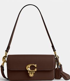 From COACH, the Glove-Tanned Leather Studio Baguette Shoulder Bag features: Glove-tanned leatherPush-lock closureFabric liningEight credit card slotsInside multifunction pocketsOutside open pocketDetachable handleDetachable strap for shoulder or crossbody wearApprox. 7.75" L x 4.25" H x 2.5" W bag; 8.25" handle drop; 21.5" strap drop Imported. Coach Fall Bag, Fall Purses And Bags, Studio Baguette Bag Coach, Brown Baguette Bag With Branded Hardware For Travel, Formal Brown Baguette Bag With Branded Hardware, Brown Baguette Shoulder Bag With Branded Hardware, Brown Shoulder Baguette Bag With Branded Hardware, Coach Rectangular Shoulder Bag With Brass Hardware, Elegant Coach Baguette Bag With Detachable Strap