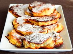 powdered sugar covered pastries on a white plate