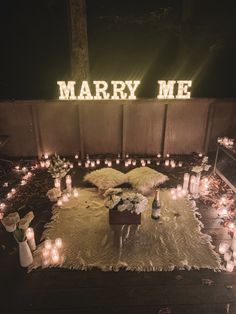 many candles are lit in front of a sign that says marry me