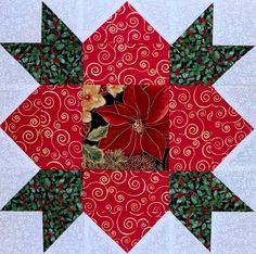 a red and white quilted christmas decoration with poinsettis on it's center