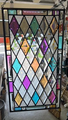 a colorful stained glass window hanging from a ceiling